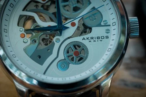 Exposed mechanical watch caliber revealing balance cock and golden balance wheel