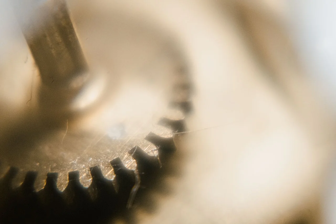 Precision cut brass watch gear train showing tooth profile and pinion alignment