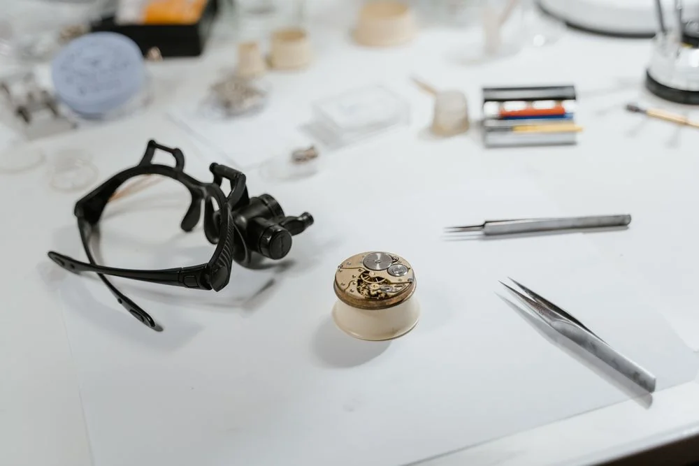 Detailed view of watchmaking tools and watch parts on a workbench in Québec City